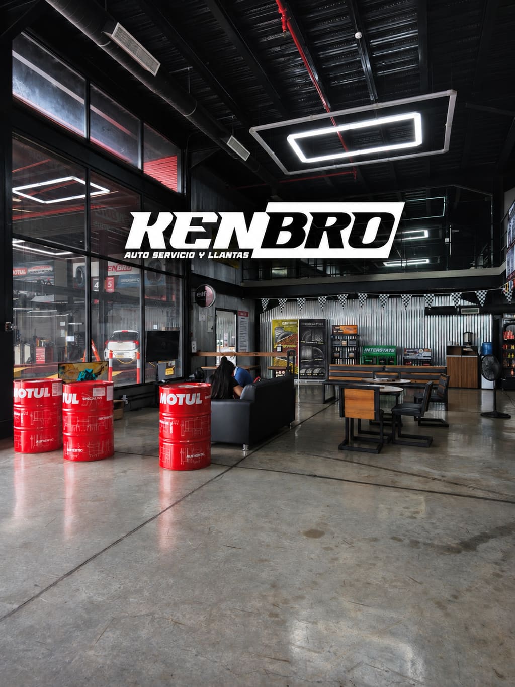 Interior de Kenbro con el logo de Kenbro Auto Servicio y Llantas, barriles de Motul y sala de espera